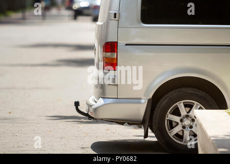 Close-up Seite Detail anzeigen Silber Passagier mittelgroß Luxus Minibus Transporter mit Zugöse auf Sommer sonnigen Stadt Straße Bürgersteig mit unscharfen Sil geparkt Stockfoto