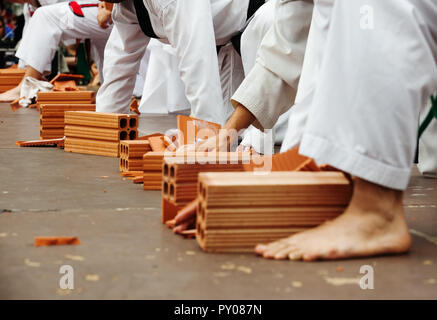 Karate Schüler zeigen ihr können durch das brechen von Steinen Stockfoto