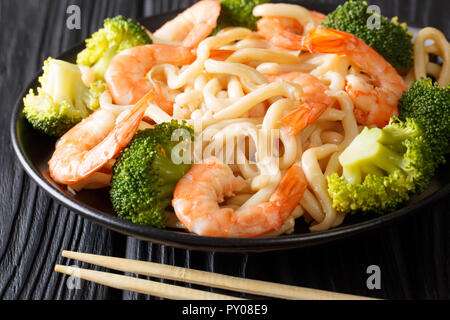 Köstliche asiatische Udon Nudeln mit Garnelen und Brokkoli closeup auf einem Teller auf den Tisch. Horizontale Stockfoto