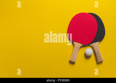Tischtennis Schläger auf gelbe Oberfläche Stockfoto