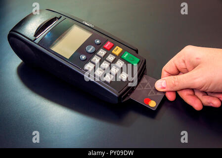 Männliche Hand wählt Pin-code auf PIN-Pad von card Maschine oder pos-terminal mit eingefügten leeren weißen Kreditkarte auf weißem Hintergrund. Zahlung mit c Stockfoto