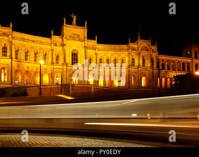 Das historische Gebäude Maximillianeum in München, Stadt in Bayern, Teil von Deutschland bei Nacht mit Lichtstrahlen von einem vorbeifahrenden Straßenbahn durch lange Belichtung Stockfoto