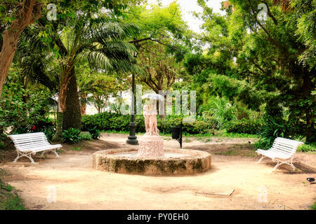 Einer der Brunnen des Parks Genoves, in Cadiz, Spanien, mit den Skulpturen von zwei Kindern unter einen Schirm eingerichtet Stockfoto