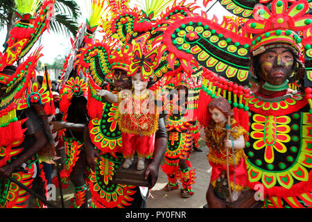 Menschen mit Schwarz verschmierten Gesichter in tribal Kostüme holding Jesus Kind Figuren bei Ati Atihan Festival, Kalibo, Aklan, Panay Island, Philippinen Stockfoto