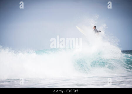 Männliche surfer Trick aus, Welle am North Shore von Oahu tagsüber, Hawaii, USA Stockfoto