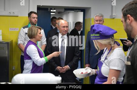 Der russische Präsident Wladimir Putin, Mitte, erfüllt mit Schülern und Lehrern bei einer Tour durch die technische Workshops an der Technograd Freizeit- und Bildungseinrichtungen komplexe VDNKh Oktober 23, 2018 in Moskau, Russland. Stockfoto