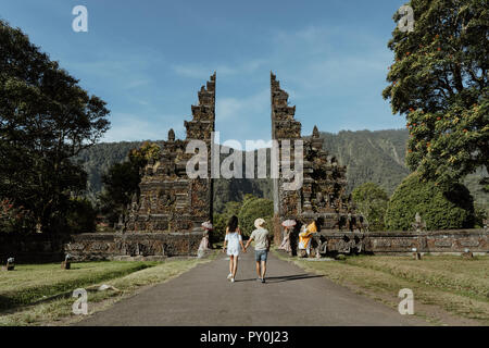 Der Mann und die Frau zu Fuß durch Bali traditionellen Gate Stockfoto