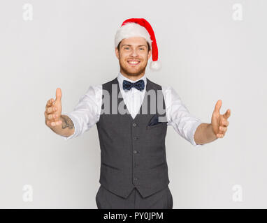 Glückliche Menschen in santa hut Holding etwas Imaginäres Stockfoto