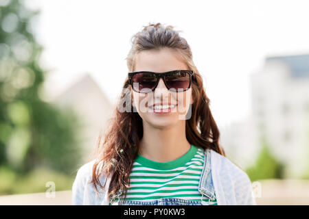 Porträt der jungen Frau in Sonnenbrille im Freien Stockfoto