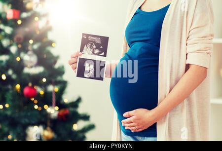 Schwangere Frau mit Ultraschall Bilder zu Weihnachten Stockfoto