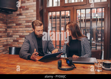 Junge Geschäftsleute zusammen Arbeiten auf Papier arbeiten und sprechen über Berichte und Finanz im Cafe. Stockfoto