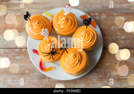 Halloween Party Cupcakes mit Dekorationen auf Platte Stockfoto