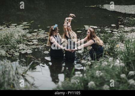 Drei boho Frauen tanzen in einen See, Russland Stockfoto