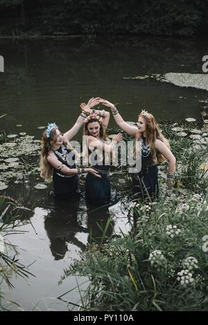 Drei boho Frauen tanzen in einen See, Russland Stockfoto