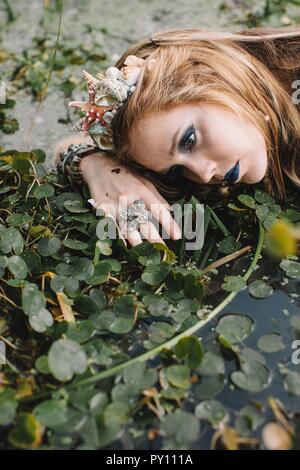 Porträt einer Boho liegende Frau im See, Russland Stockfoto