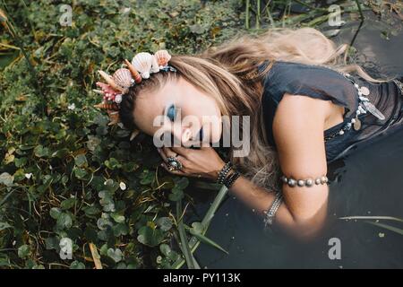 Porträt einer Boho liegende Frau im See, Russland Stockfoto