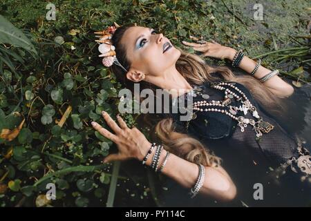 Porträt einer Boho liegende Frau im See, Russland Stockfoto