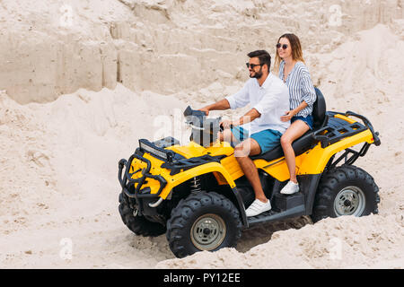 Schöne junge Paar reiten gelb Geländewagen in der Wüste Stockfoto