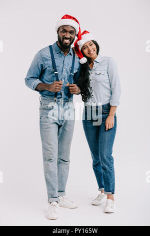 Lächelnd afrikanische amerikanische Ehepaar in Santa Hüte an Kamera isoliert auf weißem suchen Stockfoto