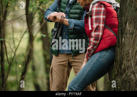 7/8 Schuß von Paar reisende Kontrolle Zeit im Wald Stockfoto