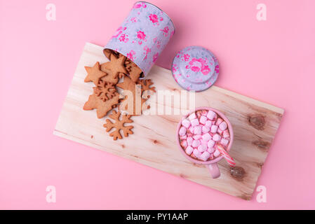 Minimalistische Weihnachten, eine Tasse heiße Schokolade mit Marshmallows und Candy Cane, ein Umgeworfen, mit Lebkuchen Cookies auf einer hölzernen Platte. Stockfoto