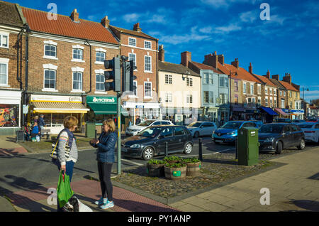 Die Hauptstraße der Stadt Stokesley North Yorkshire an einem sonnigen Herbsttag Damen von der Straße Fußgänger überqueren chatten Stockfoto