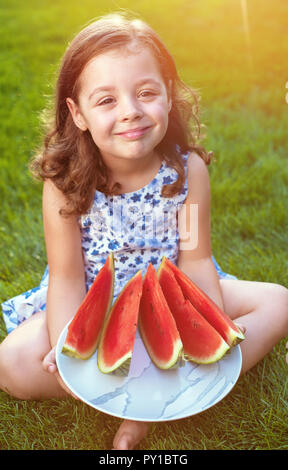 Portrait von lächelnden, cute girl Holding Wassermelone im Garten Stockfoto