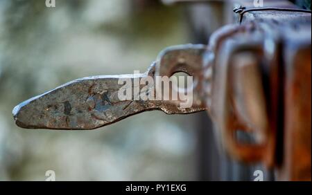 Alte rostige Bügeleisen Sperre auf eine Tür. Ländliche Objekt eine Landschaft Gefühl. Altmodische handgefertigten Objekt mit interessanten Oberfläche Muster. Stockfoto
