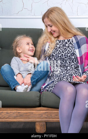 Die Mutter erzählt ihrer Tochter eine lustige Geschichte Stockfoto