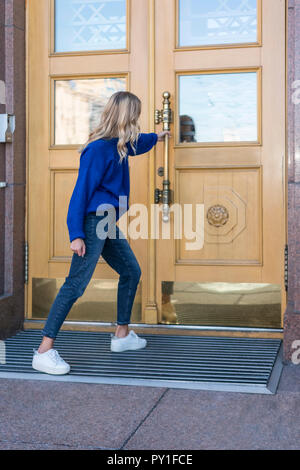 Frau zieht eine geschlossene Tür Stockfoto