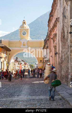 ANTIGUA, GUATEMALA - Februar 24, 2018: unbekannter Mann verkaufen Hüte Spaziergänge unter der berühmten Santa Catalina arch in der touristischen Stadt von Antigua, Guatemala Stockfoto