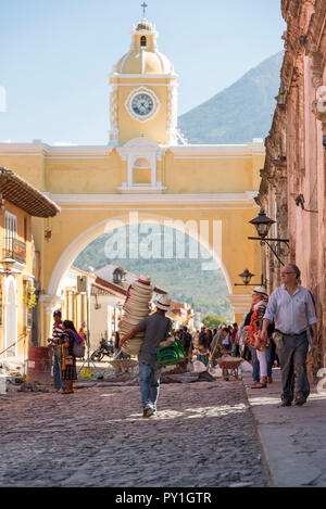 ANTIGUA, GUATEMALA - Februar 24, 2018: unbekannter Mann verkaufen Hüte Spaziergänge unter der berühmten Santa Catalina arch in der touristischen Stadt von Antigua, Guatemala Stockfoto