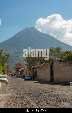 ANTIGUA, GUATEMALA - Februar 24, 2018: Straßenszenen in der beliebten Touristenstadt Antigua, Guatemala mit Volcan de Agua im Hintergrund. Stockfoto