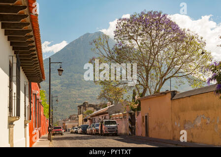 ANTIGUA, GUATEMALA - Februar 24, 2018: Straßenszenen in der beliebten Touristenstadt Antigua, Guatemala mit Volcan de Agua im Hintergrund. Stockfoto