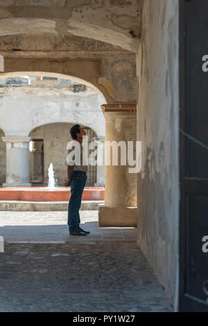 ANTIGUA, GUATEMALA - Februar 24, 2018: unbekannter Mann sieht die Architektur der beliebten Kolonialstadt Antigua, Guatemala. Stockfoto