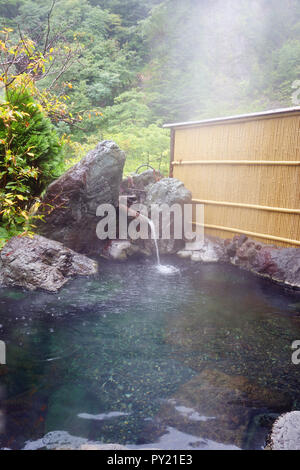 Dampfend heißen Rotenburo (Outdoor Bad) im Regen, sakamaki Onsen Ryokan, Präfektur Nagano, Matsumoto, Honshu, Japan. Keine PR