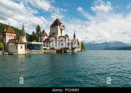 Schöne kleine Turm von Oberhofen Burg in Thun-See mit den Bergen im Hintergrund in der Schweiz, in der Nähe von Bern Stockfoto