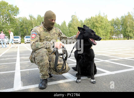 Soldat des KORD Einheit (Ukrainisch SWAT) in Uniform und seine Polizei Hund sitzt auf einem Boden. September 5, 2018. Kiew, Ukraine Stockfoto