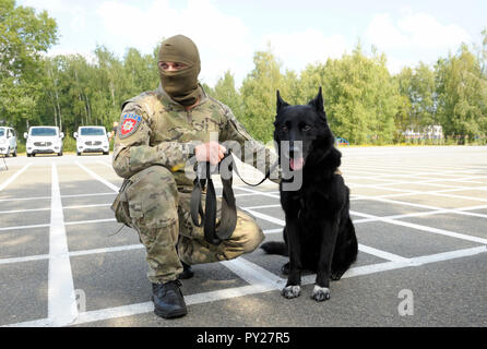 Soldat des KORD Einheit (Ukrainisch SWAT) in Uniform und seine Polizei Hund sitzt auf einem Boden. September 5, 2018. Kiew, Ukraine Stockfoto