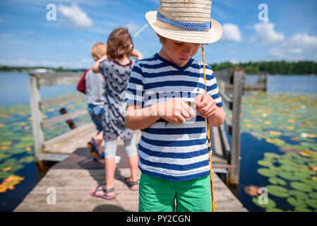 Drei Kinder Angeln auf einem Dock im Sommer, United States Stockfoto