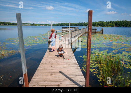 Drei Kinder Angeln auf einem Dock im Sommer, United States Stockfoto