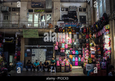 ISFAHAN, IRAN - 20. AUGUST 2018: Straße der Isfahan Bazar am Nachmittag, mit Kaufleuten sitzen und den Verkauf der Schule Rucksäcke im überdachten Mark Stockfoto