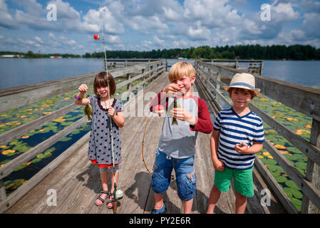 Drei Kinder Angeln auf einem Dock im Sommer, United States Stockfoto