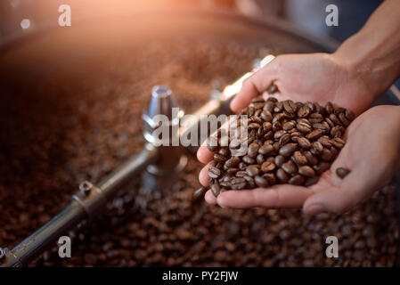 Nahaufnahme der Hand einer Frau mit gerösteten Kaffeebohnen Stockfoto