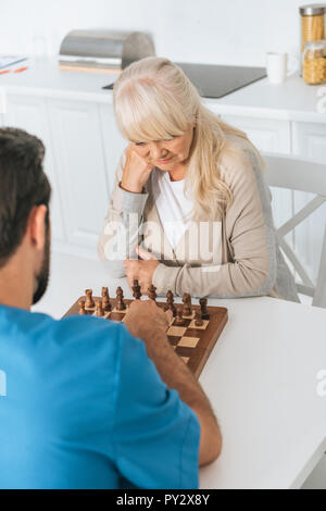 Hohe Betrachtungswinkel und der fokussierten ältere Frau spielt Schach mit Betreuer Stockfoto