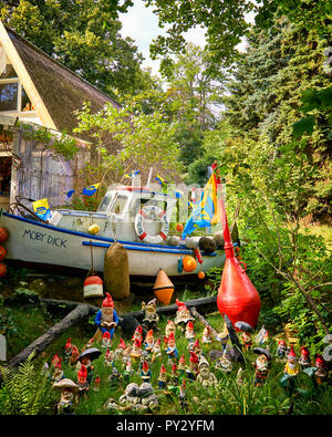 Einige dekorative Gartenzwerge, vor einem alten Boot Garten dekorieren. Stockfoto