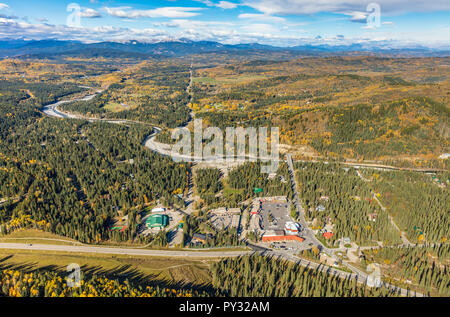 Luftaufnahme des Weilers Bragg Creek, Alberta mit Elbow River und Rocky Mountains im Hintergrund. Stockfoto