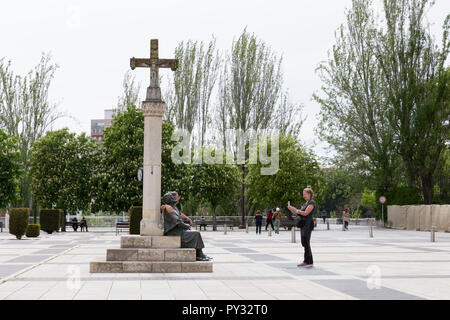 León, Spanien: Pilgern auf dem Camino Frances Route des Jakobswegs nehmen Sie Fotos mit der Bronzeskulptur eines Pilgers auf der Plaza San Marcos. Stockfoto