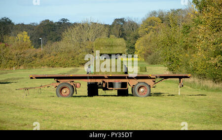 Heuballen werden auf ein Anhänger, der mit einem Traktor geladen. Stockfoto