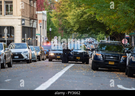 Portland, OR/USA - vom 6. Oktober 2018: Mehrere Polizeiwagen blockieren eine Straße in der Innenstadt am Abend. Zwei Offiziere mit Laptops am Tatort. Stockfoto